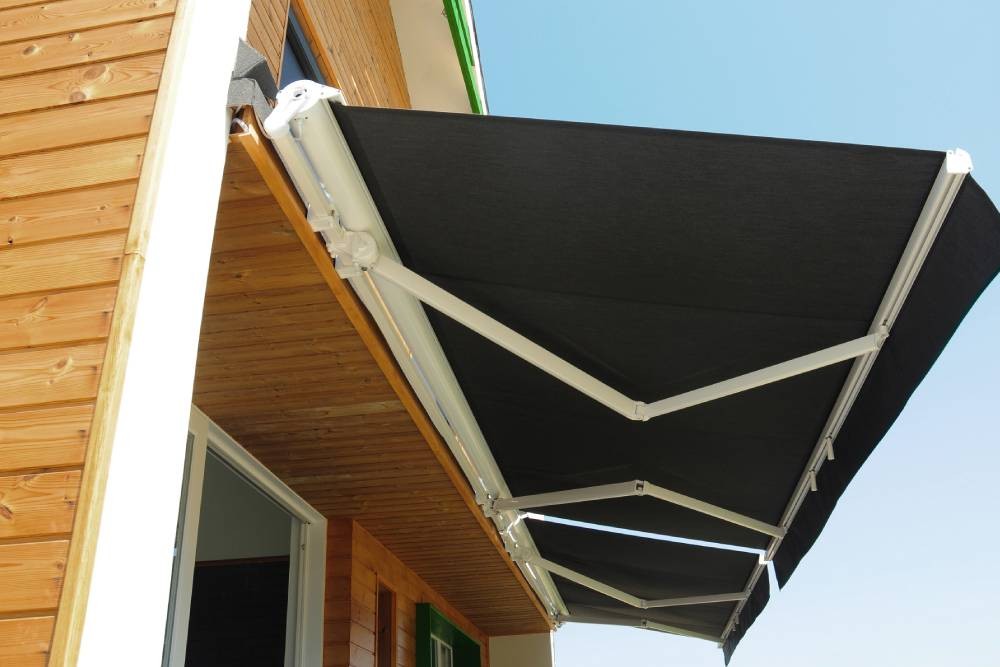 A retractable awning with black fabric near Greenwich, Connecticut (CT)